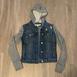 Distressed jean jacket with sweatshirt sleeves